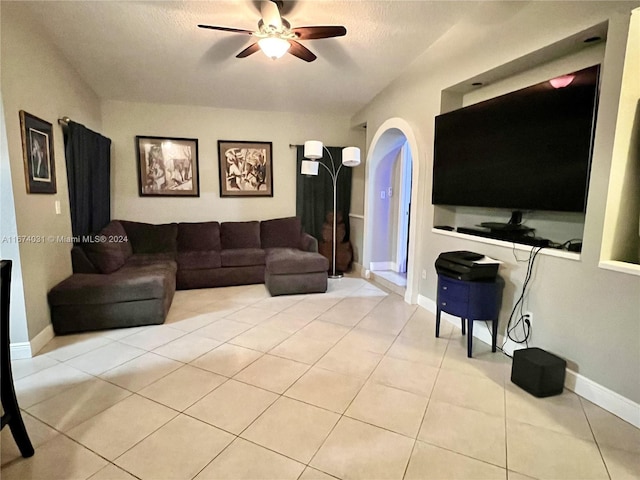 living room with ceiling fan, light tile patterned floors, and a textured ceiling