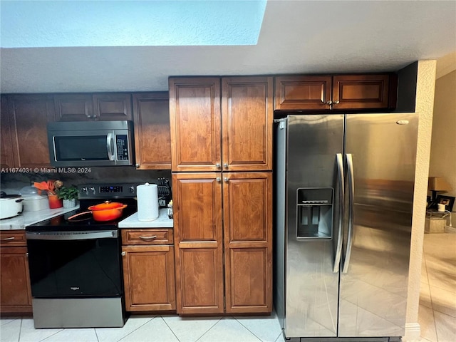 kitchen featuring stainless steel appliances and light tile patterned floors