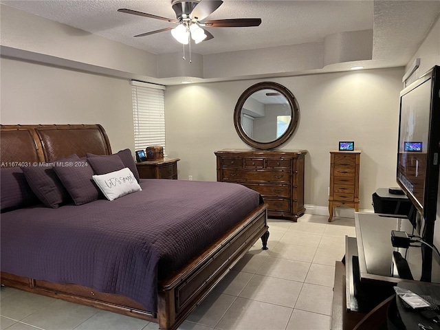 tiled bedroom featuring ceiling fan and a textured ceiling