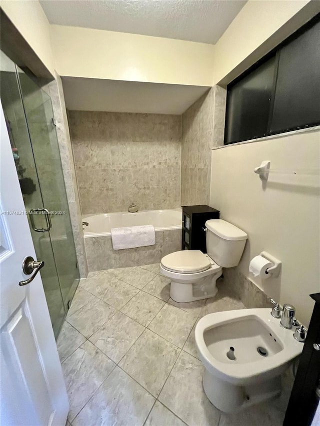 bathroom featuring a textured ceiling, toilet, a bidet, and shower with separate bathtub