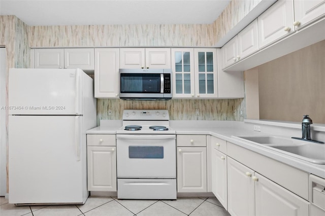 kitchen featuring white cabinets, sink, and white appliances