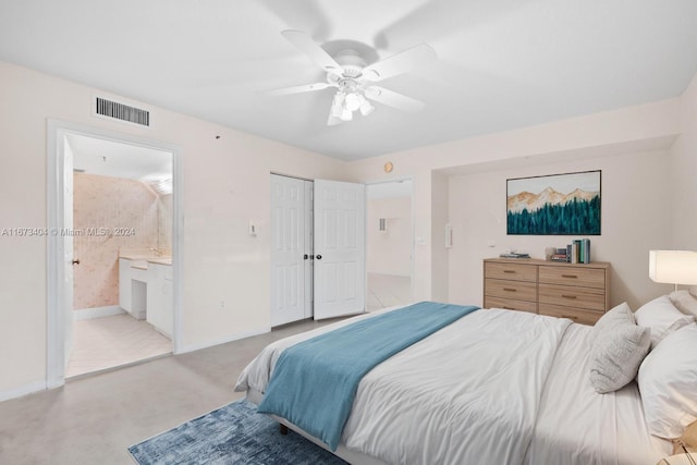 bedroom featuring ceiling fan, a closet, light carpet, and ensuite bathroom