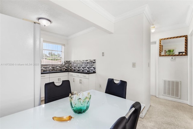 dining space with beam ceiling, sink, and a textured ceiling