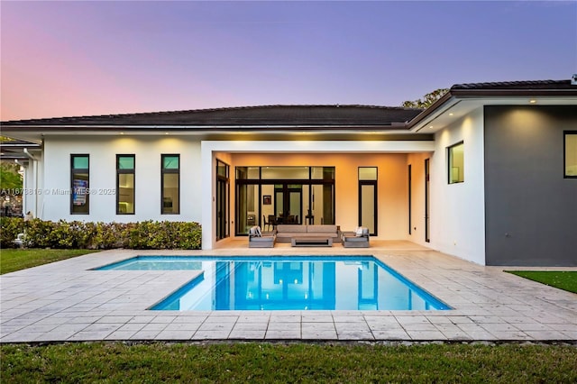 back house at dusk featuring an outdoor hangout area and a patio area