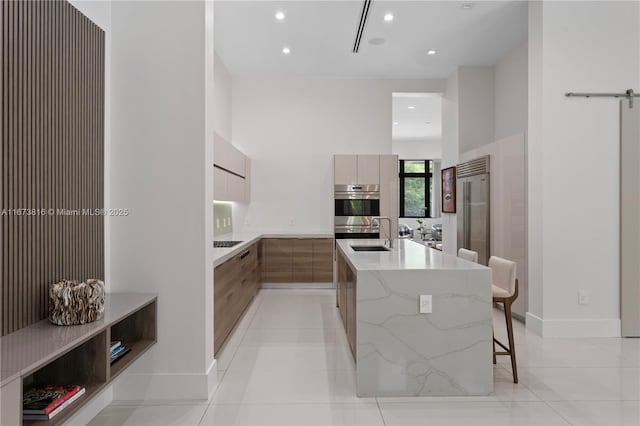 kitchen featuring electric cooktop, a kitchen breakfast bar, light tile patterned floors, light stone countertops, and stainless steel double oven