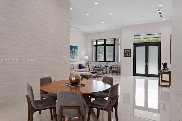 tiled dining space featuring french doors and tile walls