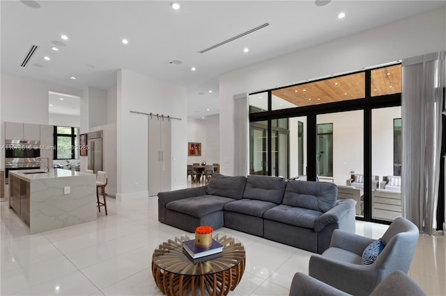 living room featuring a barn door and light tile patterned floors