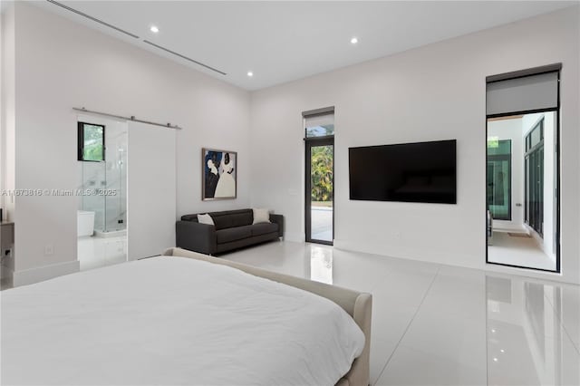 tiled bedroom featuring ensuite bath, access to outside, and a barn door