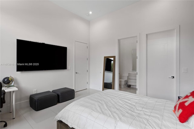 bedroom featuring ensuite bathroom and light tile patterned floors