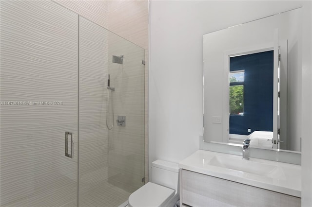 bathroom with vanity, toilet, and a shower with door