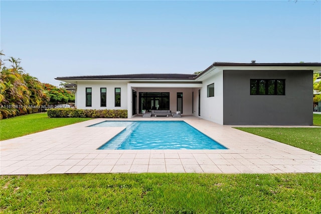 back of property with an outdoor hangout area, a patio area, and a lawn