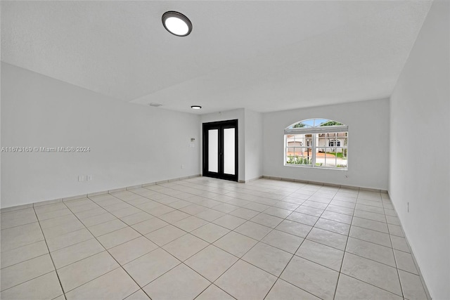 tiled spare room with french doors