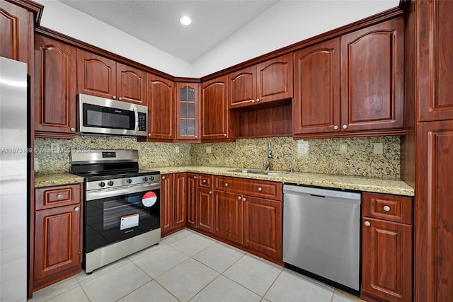 kitchen with lofted ceiling, decorative backsplash, stainless steel appliances, and sink