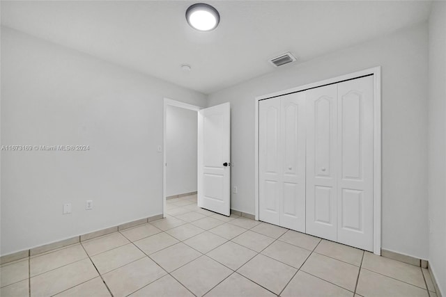 unfurnished bedroom with a closet and light tile patterned floors