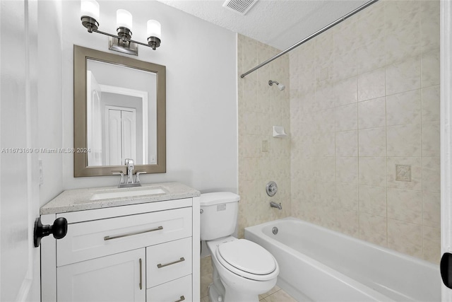 full bathroom with tiled shower / bath, a textured ceiling, toilet, vanity, and tile patterned floors