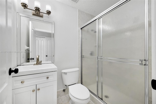 bathroom featuring toilet, a textured ceiling, walk in shower, and vanity