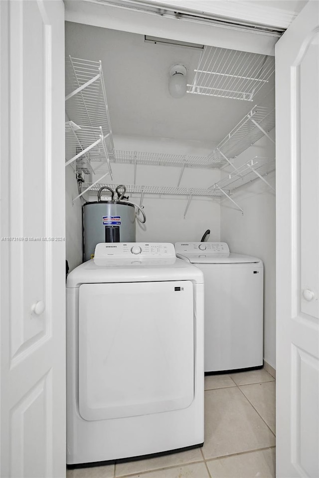 washroom with water heater, light tile patterned floors, and separate washer and dryer