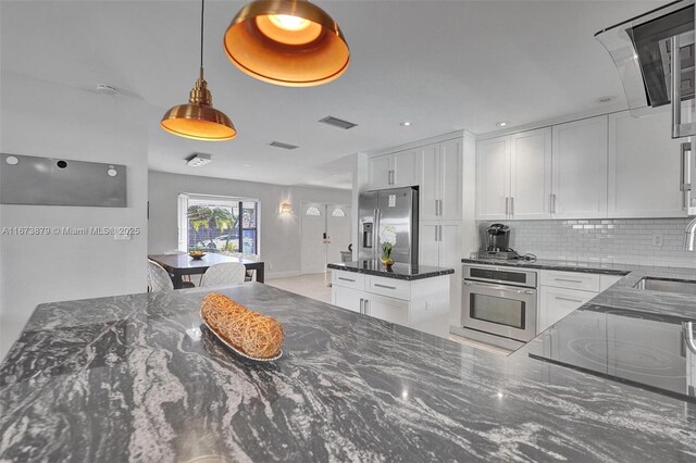 kitchen featuring tasteful backsplash, appliances with stainless steel finishes, and white cabinetry