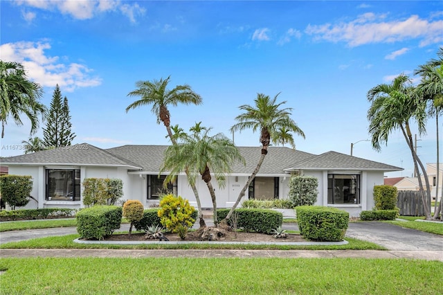 single story home with driveway, a front lawn, and stucco siding