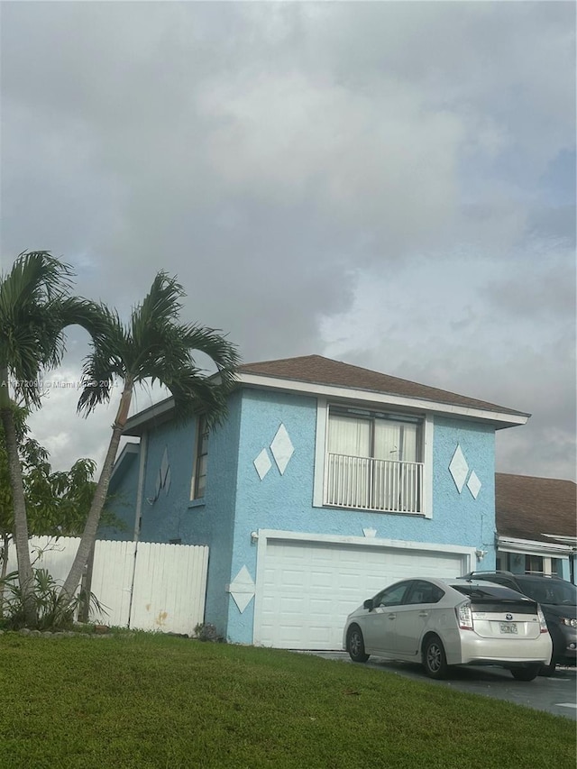 back of house featuring a garage and a yard