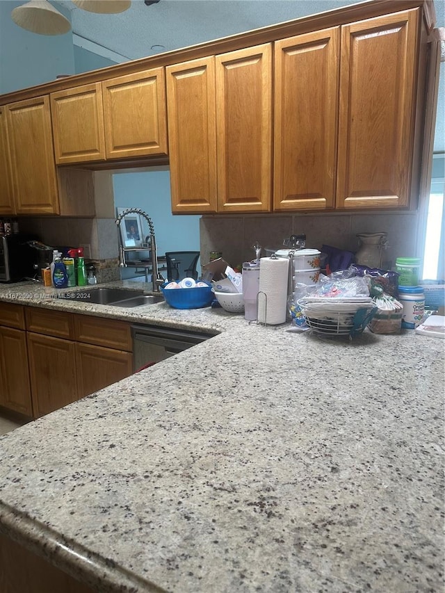 kitchen with light stone counters and sink