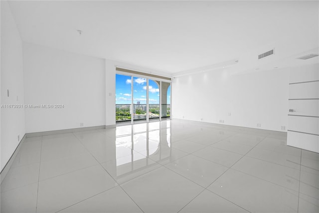 tiled empty room featuring expansive windows