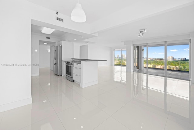 kitchen featuring appliances with stainless steel finishes, light tile patterned floors, and white cabinetry