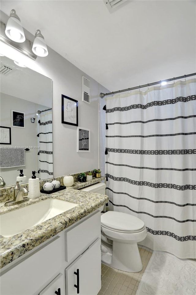 bathroom featuring tile patterned flooring, a shower with shower curtain, vanity, and toilet