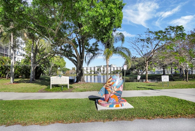 view of playground with a lawn and a water view