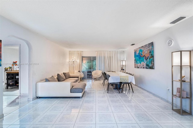 living room featuring light tile patterned floors and a textured ceiling