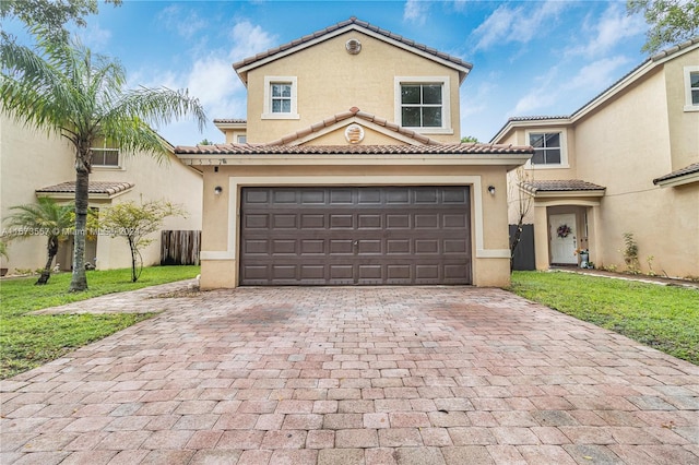 mediterranean / spanish home featuring a garage and a front yard