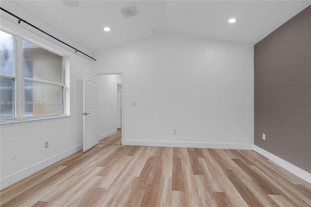 empty room featuring lofted ceiling and light wood-type flooring