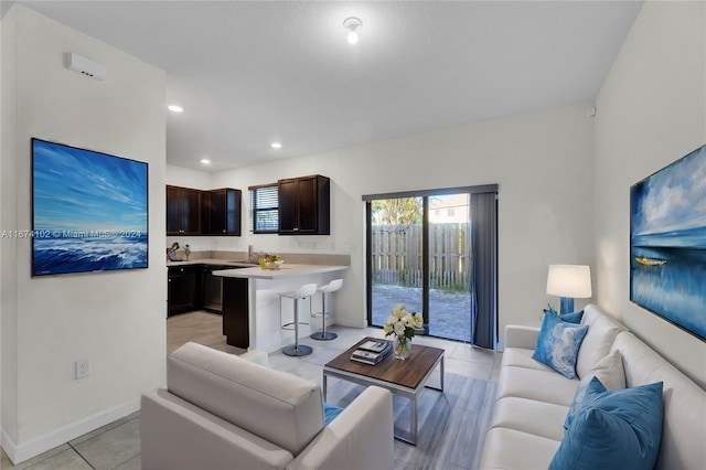 living room featuring sink and light tile patterned flooring