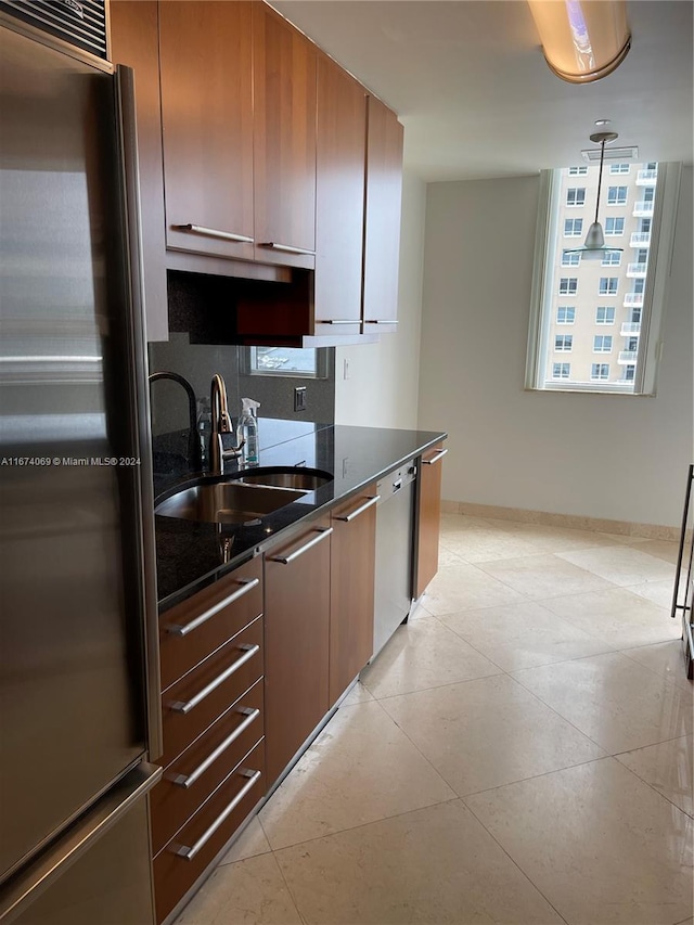 kitchen featuring decorative backsplash, pendant lighting, dark stone counters, sink, and stainless steel appliances