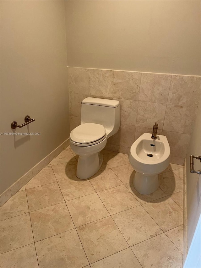 bathroom featuring toilet, tile walls, and a bidet