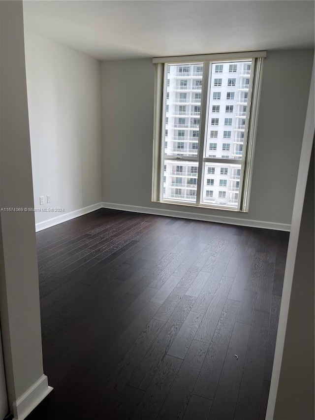 unfurnished room with dark hardwood / wood-style floors