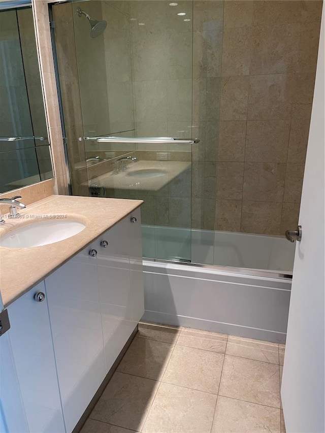 bathroom featuring bath / shower combo with glass door, tile patterned flooring, and vanity