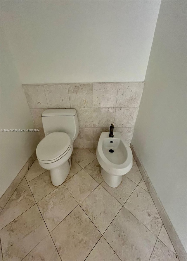 bathroom featuring a bidet, tile walls, tile patterned flooring, and toilet