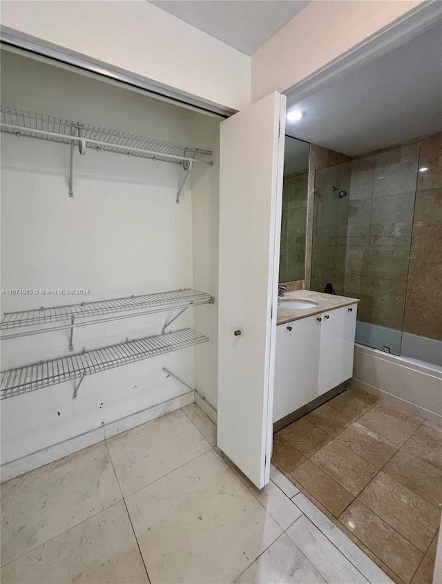 bathroom with tiled shower / bath, vanity, and tile patterned flooring