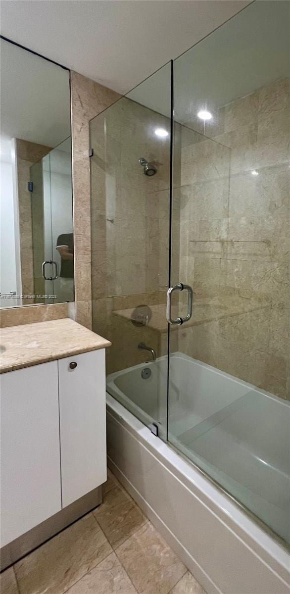 bathroom with tile patterned flooring, vanity, and enclosed tub / shower combo