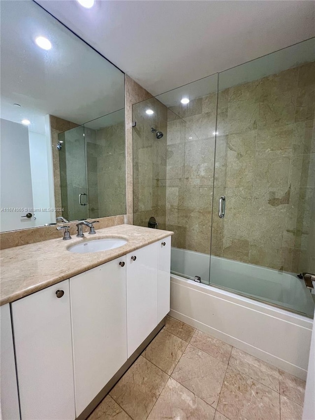 bathroom featuring bath / shower combo with glass door and vanity