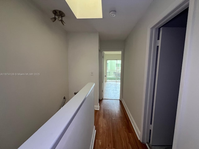 corridor featuring a skylight and dark hardwood / wood-style floors