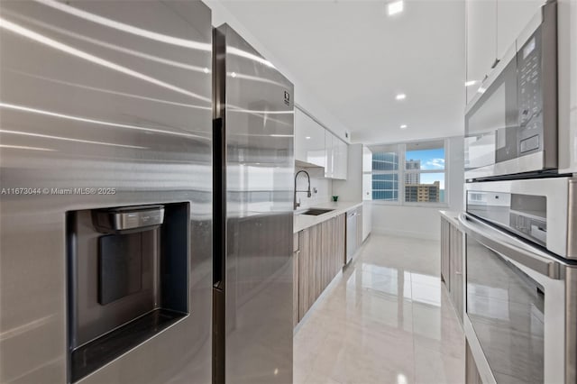 kitchen featuring white cabinetry, sink, and appliances with stainless steel finishes