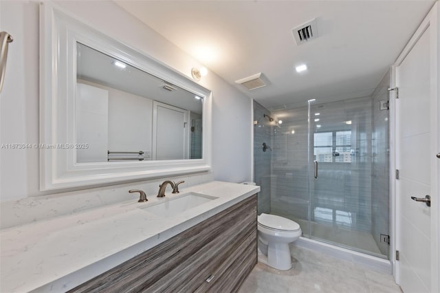 bathroom with tile patterned floors, vanity, toilet, and walk in shower