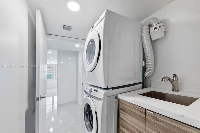 washroom with sink and stacked washer / dryer