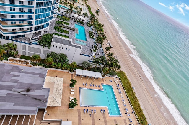 birds eye view of property with a water view and a beach view