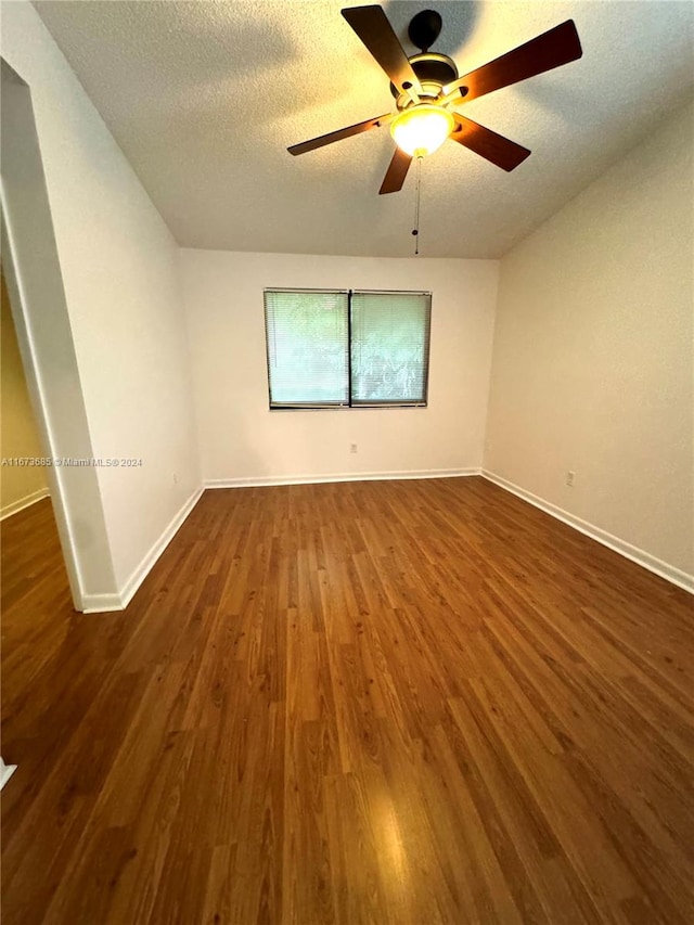 unfurnished room with a textured ceiling, ceiling fan, and dark hardwood / wood-style flooring