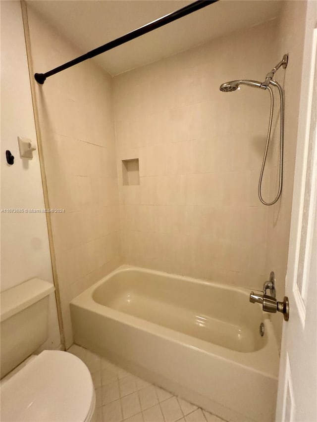 bathroom with tiled shower / bath, toilet, and tile patterned floors