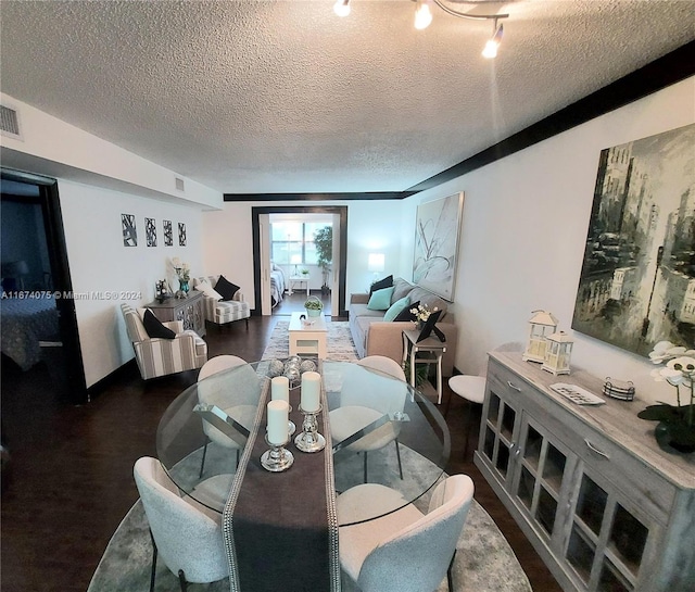 dining room with a textured ceiling and dark hardwood / wood-style floors