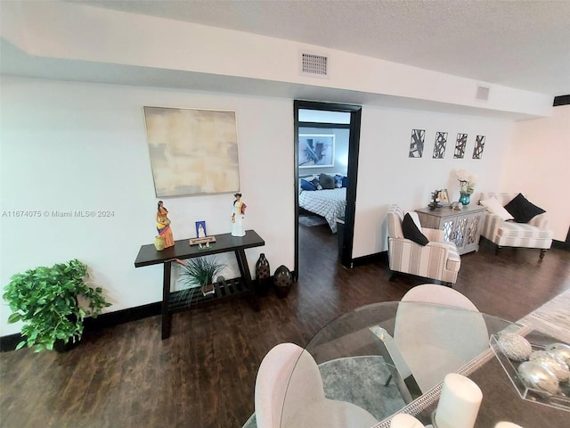 living room with a textured ceiling and dark hardwood / wood-style flooring